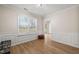 Brightly lit room featuring hardwood floors, wainscoting, and a large window at 7 Windsor Glen Dr, Durham, NC 27703