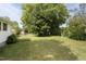 Lush backyard featuring large shade tree, green grass, and shed creates a serene outdoor space at 709 Fitzgerald Dr, Raleigh, NC 27610