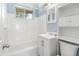 Clean bathroom featuring a tub and shower combo, white tile, and updated fixtures at 709 Fitzgerald Dr, Raleigh, NC 27610