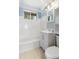 Well-lit bathroom with bathtub, white tile, modern fixtures, and a window at 709 Fitzgerald Dr, Raleigh, NC 27610