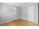 Cozy bedroom featuring hardwood floors, fresh blue paint, white trim and a window at 709 Fitzgerald Dr, Raleigh, NC 27610