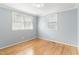 Bright bedroom featuring hardwood floors, two windows, and light blue walls at 709 Fitzgerald Dr, Raleigh, NC 27610
