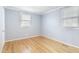 Bright bedroom features hardwood floors, neutral walls, and two windows allowing for plenty of natural light at 709 Fitzgerald Dr, Raleigh, NC 27610