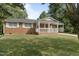Beautiful brick home with a covered porch and carport in a lush green yard at 709 Fitzgerald Dr, Raleigh, NC 27610