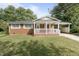 Charming brick home with a welcoming front porch and well-manicured lawn at 709 Fitzgerald Dr, Raleigh, NC 27610