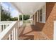 Spacious covered front porch with detailed brick flooring and white railing at 709 Fitzgerald Dr, Raleigh, NC 27610