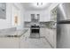 Open concept kitchen with granite counters, stainless steel appliances, and white cabinets at 709 Fitzgerald Dr, Raleigh, NC 27610