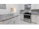 Stylish kitchen with granite countertops, stainless steel range and hood, with white cabinets at 709 Fitzgerald Dr, Raleigh, NC 27610