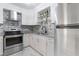 Bright kitchen with stainless steel appliances, gray backsplash, granite countertops, and white cabinetry at 709 Fitzgerald Dr, Raleigh, NC 27610