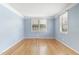 Bright and airy living room featuring hardwood floors and fresh blue paint with natural light at 709 Fitzgerald Dr, Raleigh, NC 27610