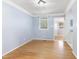 Bright room featuring hardwood floors and blue paint with pass-through to kitchen and a window at 709 Fitzgerald Dr, Raleigh, NC 27610
