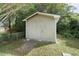 Exterior view of shed with siding and single door surrounded by lush greenery and chain link fence at 709 Fitzgerald Dr, Raleigh, NC 27610