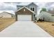 Two-story home featuring a spacious garage, driveway, and nicely contrasted neutral-colored siding at 801 Berkeley Glen Rd, Zebulon, NC 27597