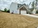 Side view of a two-story home with a spacious garage and neutral-colored siding at 801 Berkeley Glen Rd, Zebulon, NC 27597