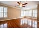Bright bedroom with hardwood floors, white trim, ceiling fan, and large windows at 804 Long Meadows Rd, Chapel Hill, NC 27516