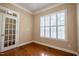 Sunny room with hardwood floors and a window with white shutters and a glass paneled door at 804 Long Meadows Rd, Chapel Hill, NC 27516