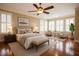Comfortable main bedroom features hardwood floors, area rug, ceiling fan, sitting area, and many windows with plantation shutters at 804 Long Meadows Rd, Chapel Hill, NC 27516