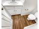 Cozy half bathroom with a wood-look floor, white vanity, and modern fixtures at 8425 Fawncrest Dr, Raleigh, NC 27603