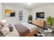 This staged bedroom features a wooden bed frame and dresser with plants and modern decor at 8425 Fawncrest Dr, Raleigh, NC 27603