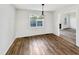 Bright dining area featuring hardwood floors, modern chandelier, and a sunlit window view at 8425 Fawncrest Dr, Raleigh, NC 27603