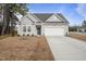 Charming single-Gathering home featuring a two-car garage, a well-manicured front yard, and a blue sky at 88 Molly Mac Ln, Angier, NC 27501