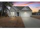 Charming single-Gathering home featuring a two-car garage and a well-manicured front yard at sunset at 88 Molly Mac Ln, Angier, NC 27501