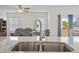 Modern kitchen sink with granite countertops, stainless steel appliances, and a view of the living area at 88 Molly Mac Ln, Angier, NC 27501