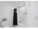 Bathroom featuring a tub with a shower, white tile walls and marble tile floors at 905 N Hyde Park Ave, Durham, NC 27701
