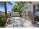 View of the concrete driveway leading to a detached garage, accented by lush landscaping and a wooden staircase at 905 N Hyde Park Ave, Durham, NC 27701