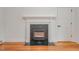 Fireplace with black tile surround, white mantel, hardwood floors, and modern design at 905 N Hyde Park Ave, Durham, NC 27701