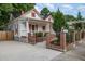 Inviting front exterior features brick accents, a black iron fence, and lush landscaping framing this charming home at 905 N Hyde Park Ave, Durham, NC 27701