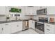 Modern kitchen with stainless steel appliances, white cabinets, dark countertop, and ample natural light at 905 N Hyde Park Ave, Durham, NC 27701