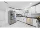 Modern kitchen featuring stainless steel appliances, white cabinetry, and sleek black countertops for a contemporary design at 905 N Hyde Park Ave, Durham, NC 27701
