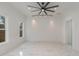 Bright and airy living room with white marble floors, white walls and a modern ceiling fan at 905 N Hyde Park Ave, Durham, NC 27701