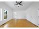 Main bedroom featuring hardwood floors, a modern ceiling fan, and large windows at 905 N Hyde Park Ave, Durham, NC 27701