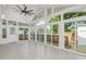 Bright sunroom with large windows, tile flooring, and a ceiling fan providing ample natural light and comfort at 905 N Hyde Park Ave, Durham, NC 27701