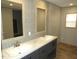 This is a bathroom with a double sink vanity, framed mirrors, and neutral-toned wall tiles at 9115 Nc 157, Rougemont, NC 27572