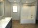 Bathroom with tub/shower combo, gray vanity, and neutral color scheme at 9115 Nc 157, Rougemont, NC 27572