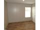 Bedroom with wood-look floors and neutral walls with a bright window at 9115 Nc 157, Rougemont, NC 27572