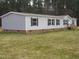Charming home featuring a mix of gray siding and brick foundation, complemented by black shutters and a natural wooded backdrop at 9115 Nc 157, Rougemont, NC 27572
