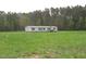 Exterior shot of house in large yard with green grass and trees in the background at 9115 Nc 157, Rougemont, NC 27572