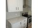 Modern kitchen with black appliances, white cabinets, a gray backsplash, and updated countertops at 9115 Nc 157, Rougemont, NC 27572