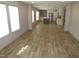 Spacious living room with light-colored wood-look floors and abundant natural light. White kitchen in the background at 9115 Nc 157, Rougemont, NC 27572