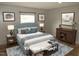 This virtually staged main bedroom has a tufted headboard, side tables and decorative art at 9115 Nc 157, Rougemont, NC 27572