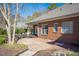 A brick home boasts a covered deck, patio, and mature trees that create a private outdoor oasis at 9413 Lake Villa Way, Raleigh, NC 27614