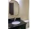 Bathroom features a dark vanity with black countertop and decorative mirror at 9413 Lake Villa Way, Raleigh, NC 27614