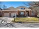Charming brick home featuring an attached two-car garage, manicured lawn, and classic architectural details at 9413 Lake Villa Way, Raleigh, NC 27614