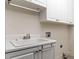 Functional laundry room featuring a utility sink, storage cabinets, and appliance connections at 9413 Lake Villa Way, Raleigh, NC 27614
