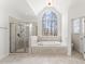 Bright primary bathroom with a walk in shower, soaking tub, and a large window at 100 Tavernelle Pl, Cary, NC 27519
