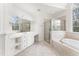 Luxurious primary bathroom with a soaking tub, walk in shower, dual vanity, and natural light at 100 Tavernelle Pl, Cary, NC 27519